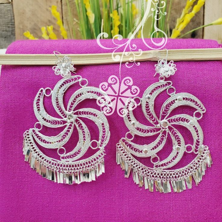 Beautiful and stunning handmade Mexican Filigree Earrings. Each piece is meticulously created out of copper wire and spun into a beautiful design. To give it the final touch artisans dipped into silver plate for it's elegant silver color. This accessory is an important part of the traditional Tehuana outfit from Oaxaca, Mexico. Look elegant while wearing Mexico's culture with this one of a kind earrings! Approximate length: 3.5-4 in Need more than one? Ask us about our combined flat rate shipmen Traditional Silver Dangle Clip-on Earrings, Traditional Handmade Metal Clip-on Earrings, Unique Silver Beaded Drop Earrings, Handmade Metal Dangle Bridal Earrings, Silver Handmade Danglers For Party, Ornate White Dangle Earrings, White Intricate Design Dangle Earrings, Bohemian Silver Bridal Earrings With Latkans, Bohemian Bridal Earrings With Latkans In Silver