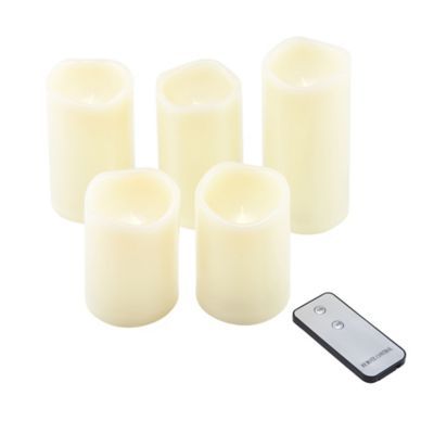 five white candles and a remote control on a white background