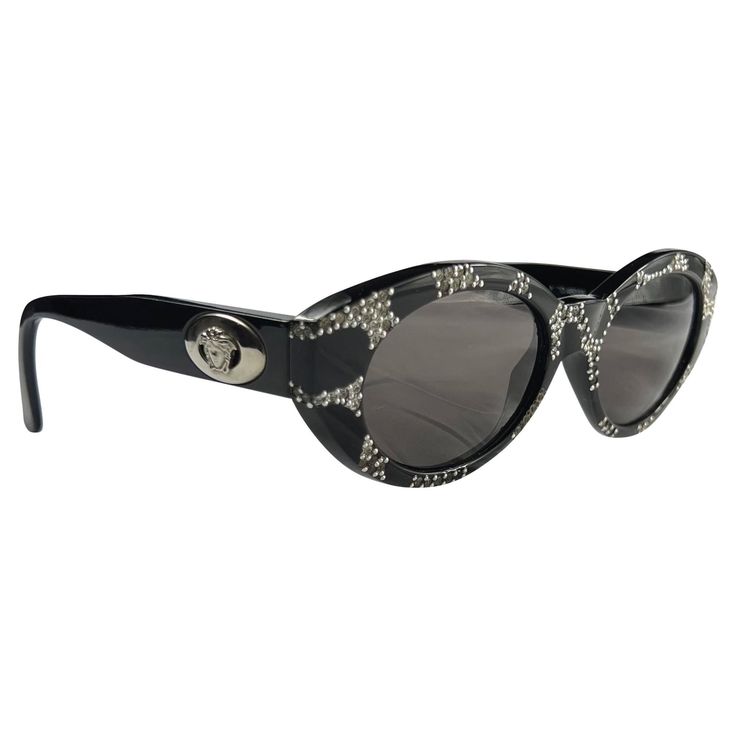 Presenting a fabulous pair of black and silvertone Cateye-style Gianni Versace sunglasses. From the 1990s, these stunning sunglasses are complete with an abstract rhinestone pattern at the front and the Versace Medusa logo on the arms. As seen on Lil Kim. Approximate Measurements: Frame height: 1.75" Frame width: 5.75" Acrylic Sunglasses, Lil Kim, Versace Sunglasses, The 1990s, Gianni Versace, Designer Sunglasses, Boho Jewelry, Sunglasses Accessories, Rayban Wayfarer