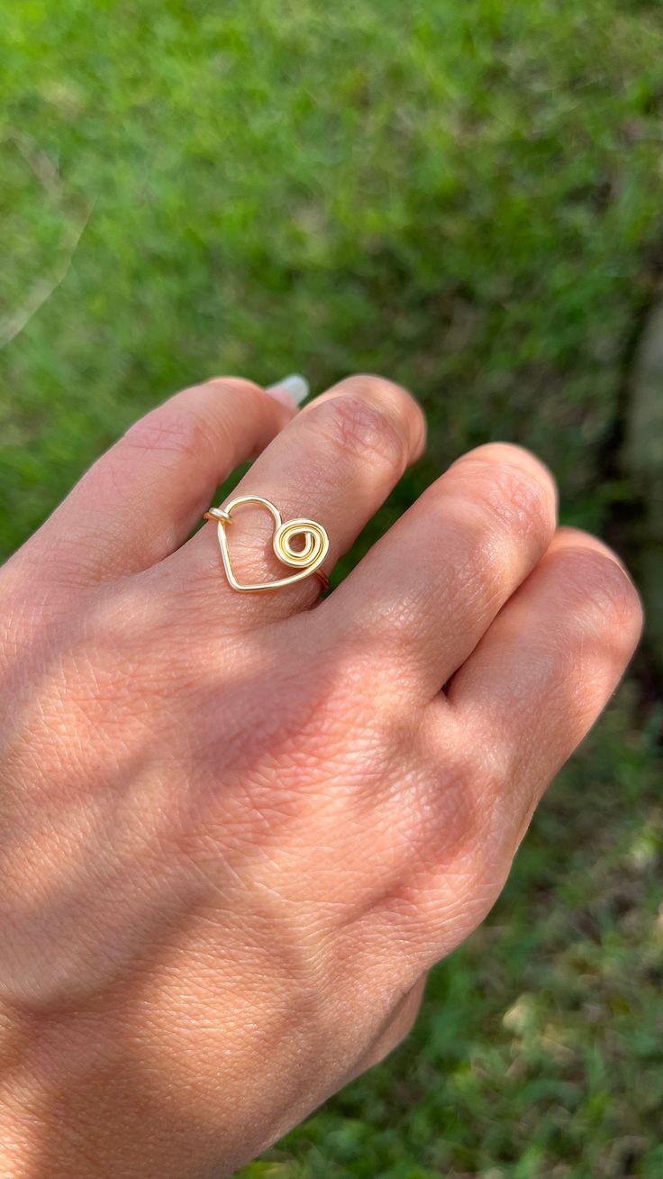 "Heart Wire Ring This delicate Heart Ring, is perfect for a  gift to that special person. You can give it as a special gift for her, or even for you to wear everyday. This is a unique design handmade with love to remind you that you are alive and have so many reason to be thankful for.  I T E M ~D E T A I L S  Materials: Gold Plated Wire 16 Size: Adjustable. Wire tones available: Gold, Rose Gold and Silver. Thank you for visiting my product. You can see more amazing designs in my shop clicking here: https://www.etsy.com/shop/NanisInspiration Share your pictures with me and get inspired with more products by following me on instagram: https://instagram.com/nanis.inspiration?igshid=1g1yi20qzd053 If you want to check more beautiful similar styles, click the links below... https://www.etsy.com Cute Gold Heart Ring For Valentine's Day, Gold Heart Ring For Valentine's Day, Cute Gold Rings For Valentine's Day, Adjustable Heart-shaped Dainty Midi Rings, Cute Gold Heart Promise Ring, Cute Heart-shaped Rings For Valentine's Day, Delicate Adjustable Open Heart Ring, Cute Heart-shaped Valentine's Day Rings, Cute Gold Heart Ring As A Gift