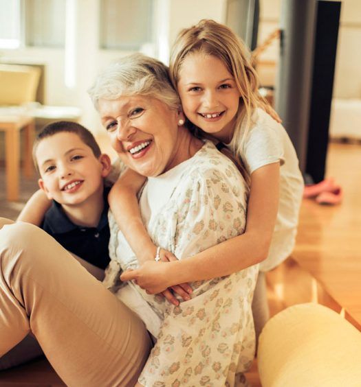 an older woman and two children sitting on the floor