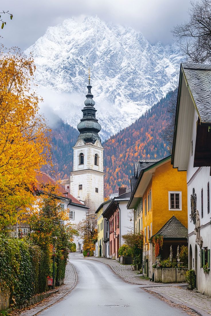 an old european village with mountains in the background and snow on the top of the mountain