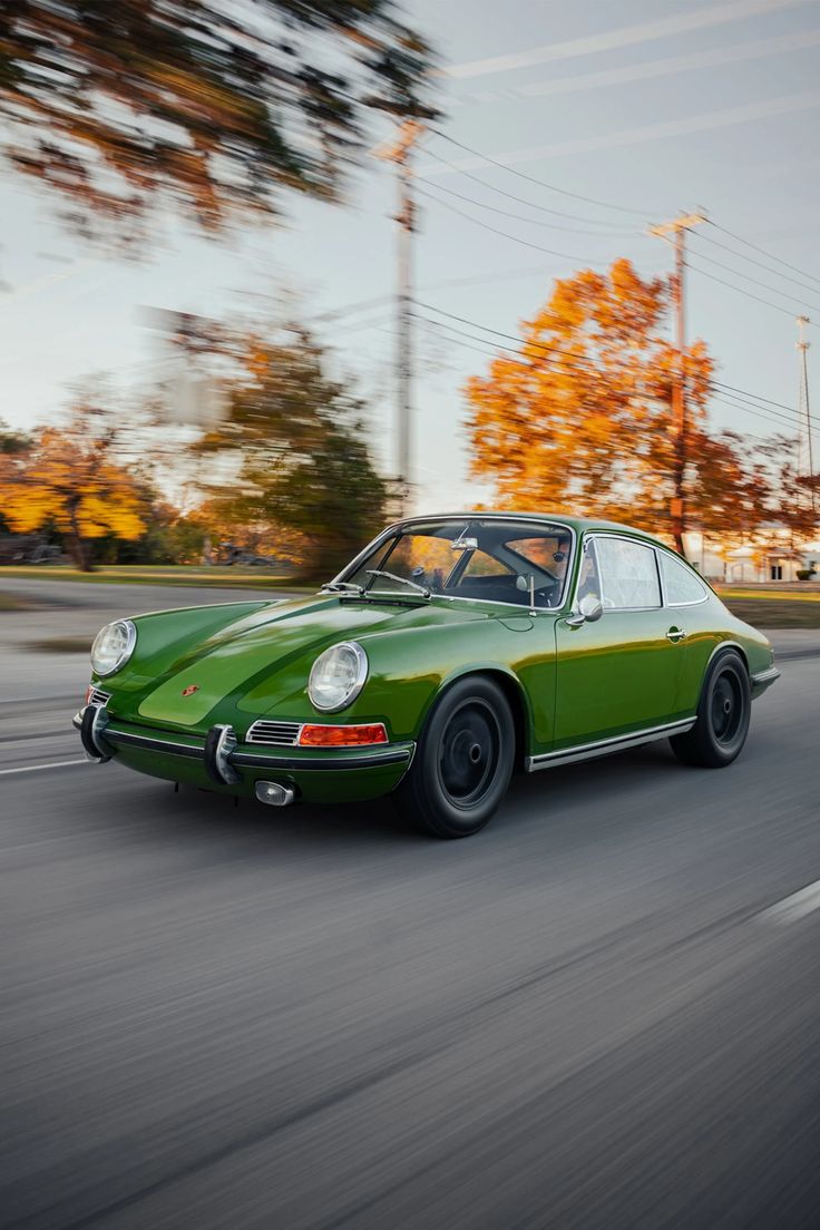 a green sports car driving down the road