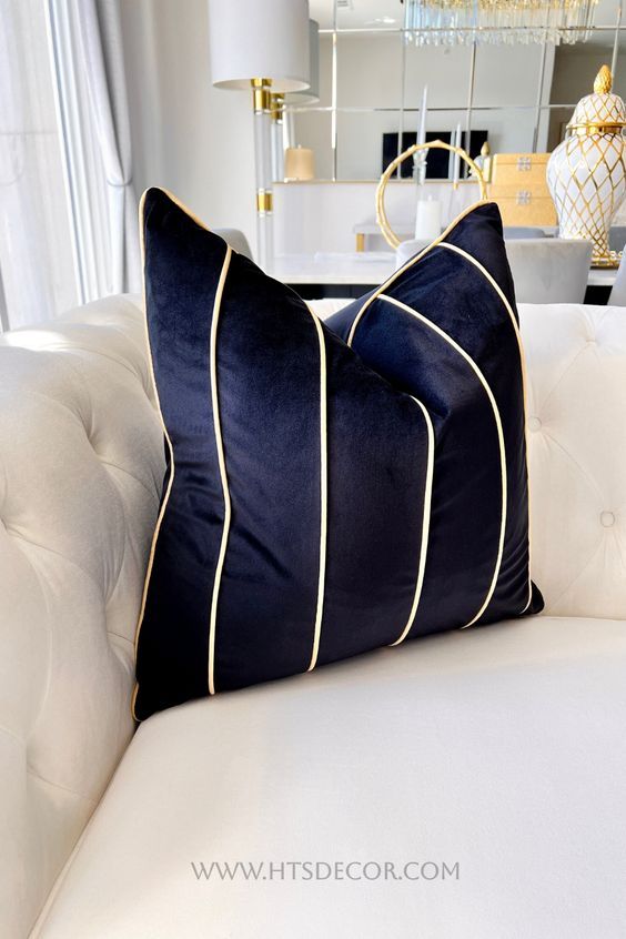 a white couch with blue and gold pillows