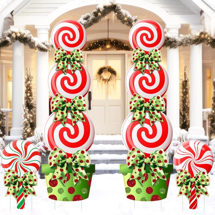 christmas decorations in front of a house with candy canes on the top and below them