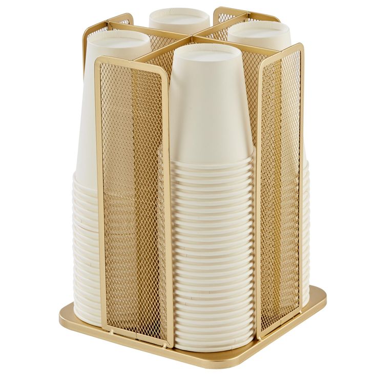 four white cups are stacked in a golden holder