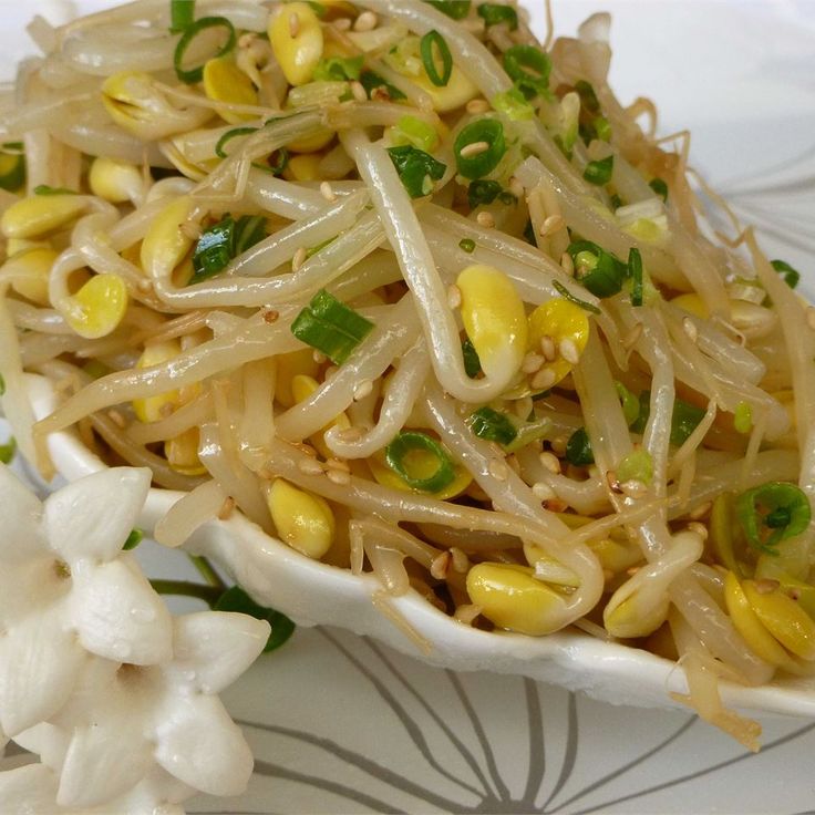 a white plate topped with noodles and corn