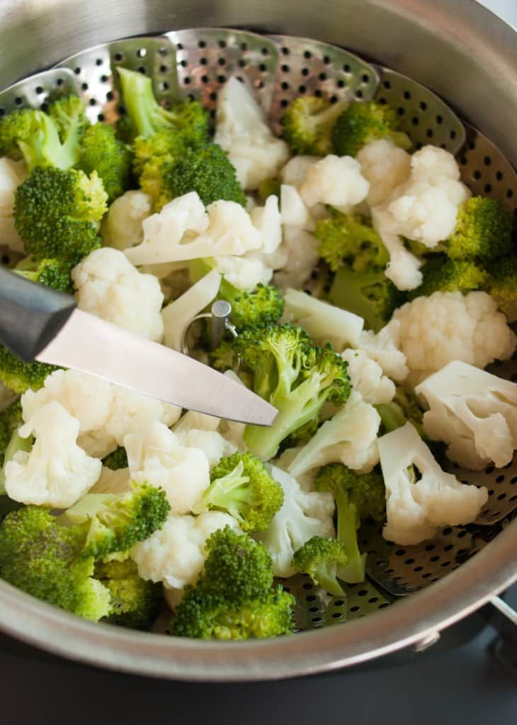 broccoli and cauliflower being cooked in a pot