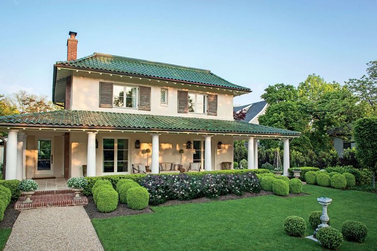 a large white house sitting on top of a lush green field