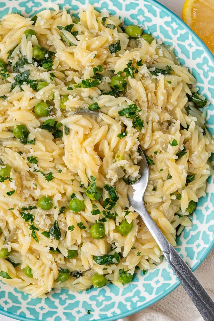 a bowl filled with pasta and broccoli on top of a blue and white plate