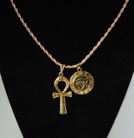 African Gold plated Duo Charm Necklace  One Large Ankh Charm and one Eye of Horus Shield Charm❤ Ankh measures 1.5 inches tall by 0.75 inches wide with a gold snap-on bale.❤ Eye of Horus Charm is 25mm wide and is hollow on back.Choose YOUR CHAIN from our pull-down menu:❤ {1} Rope Chain 2mm wide by 18 inches long with lobster clasp.OR❤ {1} Rope Chain 2mm wide by 20 inches long with lobster clasp.❤ Made-to-order and ships out from MAINE same day as ordered to USA.❤ Every order includes a FREE GIFT! Eye Of Horus Necklace, African Gold, Egyptian Necklace, Husband Valentine, Valentine Gifts For Husband, Gold Rope Chains, Birthday Gifts For Husband, Eco Gifts, Bangor