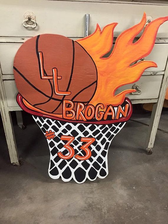 a wooden sign that has a basketball on it with flames coming out of the hoop