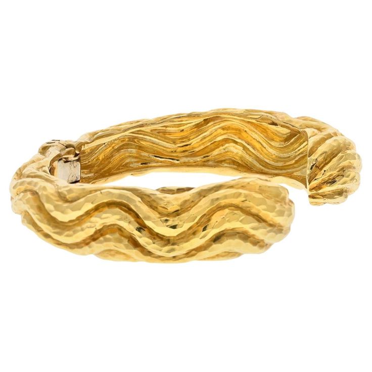 The David Webb Platinum & 18K Yellow Gold Hammered Cuff Wave Bangle Bracelet is a stunning piece of jewelry that showcases the brand's iconic style and exceptional craftsmanship. Crafted in 18K yellow gold, this cuff bracelet features a unique wave design with a hammered texture, adding depth and visual interest to the piece. The contrasting texture creates a captivating and luxurious aesthetic. The cuff style offers a bold and contemporary look, making it a statement piece that can be worn on i Luxurious Aesthetic, Hammered Bangles, David Webb, American Modern, The David, Cuff Bangle Bracelet, Iconic Style, Wave Design, Cuff Bangles