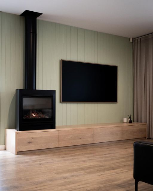 a flat screen tv mounted on the wall next to a fireplace