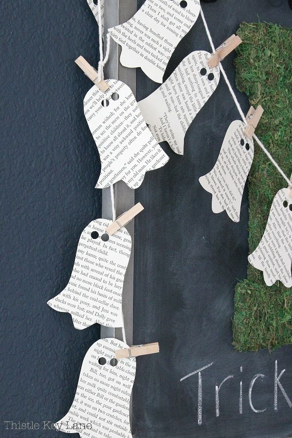 some paper ghost hanging from clothes pins with the words trick written on them and grass