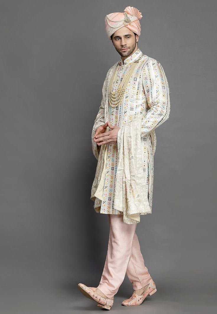 Art SilkArt Silk Sherwani in Off WhiteThis Readymade attire is Enhanced with Buttons, Mirror Effect and Resham Work. Carved in Chinese Collar Neck and Full SleeveAvailable with an Art Silk Pajama in PinkDo note: Turban, Kanthimala, Dupatta and Footwear shown in the image is for presentation purposes only. Half to one inch may vary in measurement. (Slight variation in actual color vs. image is possible)  We sell all kinds of menswear. Mens Kurta | Mens Kurta Pajama | Mens Sherwani | Mens Sherwani Bollywood Art Silk Sherwani With Chikankari Embroidery, Transitional Off White Kurta With Dupatta, Transitional Off-white Kurta With Dupatta, Bollywood Style Off-white Straight Kurta, Embroidered Raw Silk Sherwani For Navratri, Designer Art Silk Sherwani With Chikankari Embroidery, Designer Traditional Drape Off White Kurta, Art Silk Bandhgala With Chikankari Embroidery For Eid, Traditional Bandhgala With Chikankari Embroidery In Art Silk