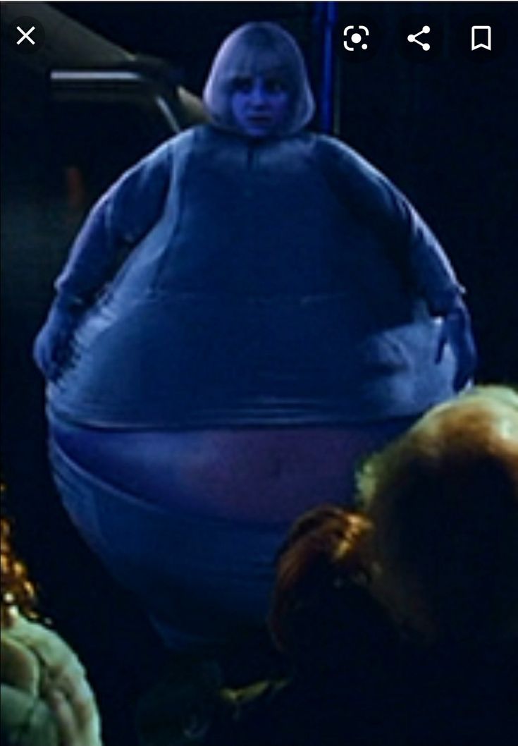 a person standing in front of a giant blue object