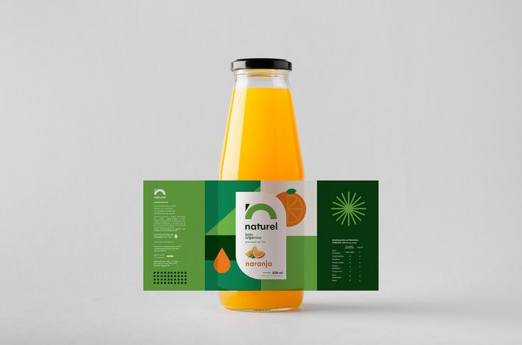 a bottle of orange juice with a business card next to it on a white surface