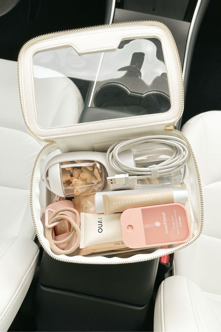 the inside of a car seat with various items in its storage bag, including an ipod and earbuds