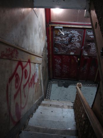 the stairs lead up to an area with graffiti on it, and there is no door