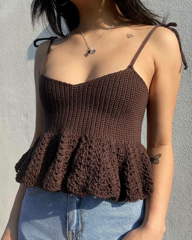 a close up of a person wearing a tank top with crochet on it