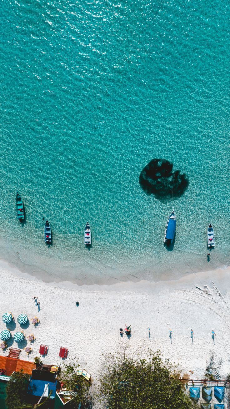 an aerial view of boats on the beach