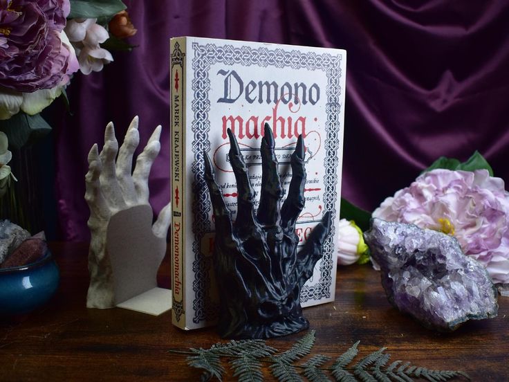 a book sitting on top of a wooden table next to purple flowers and other items