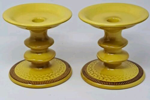 two yellow candlesticks sitting next to each other