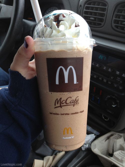 a person holding up a drink with whipped cream on top and chocolate in the middle