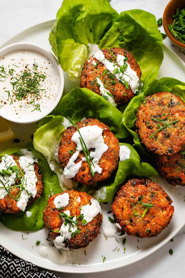 crab cakes on lettuce leaves with ranch dressing