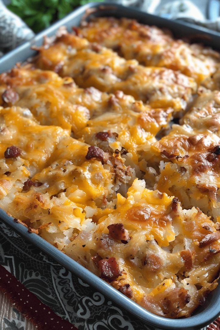 a casserole dish with cheese and meat in it sitting on a table cloth