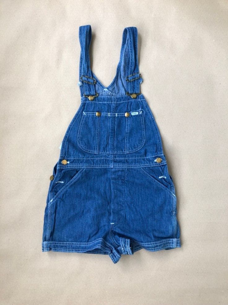 Unworn, originating from the archive of a jeans shop that closed down late last century.  Unworn vintage Lee Cut Off Shorts with tag still attached.  100% cotton, sized W28, made in USA. Pockets in the front and back and two bib pockets.  Waist from top of waistband: 71cm / 28" For information about our full terms & conditions please review our Shop Policies. Retro Cotton Dark Wash Shortalls, Vintage Cotton Medium Wash Shortalls, Retro Dark Wash Cotton Shortalls, Retro Denim Blue Overalls With Pockets, Vintage Blue Shortalls, Vintage Denim Shortalls In Medium Wash, Vintage Cotton Bottoms In Medium Wash, Vintage Medium Wash Cotton Bottoms, Vintage Denim Overalls In Medium Wash