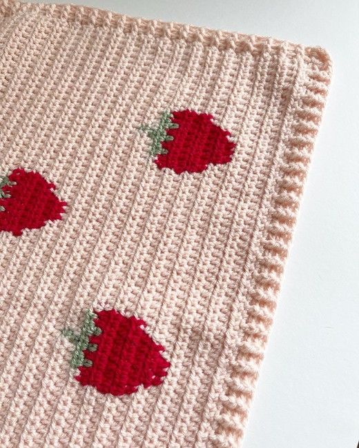 a crocheted dishcloth with strawberries on it