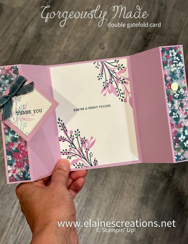 a hand holding an open card with flowers on it