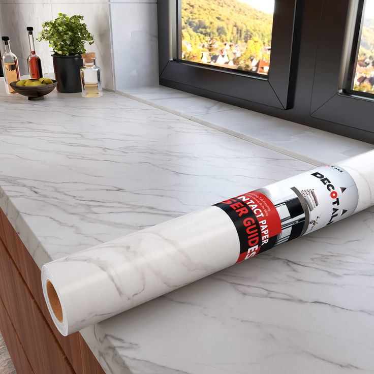 a roll of white adhesive sitting on top of a counter next to a window