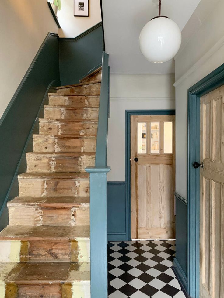 an entryway with stairs leading up to a door and checkered tile flooring