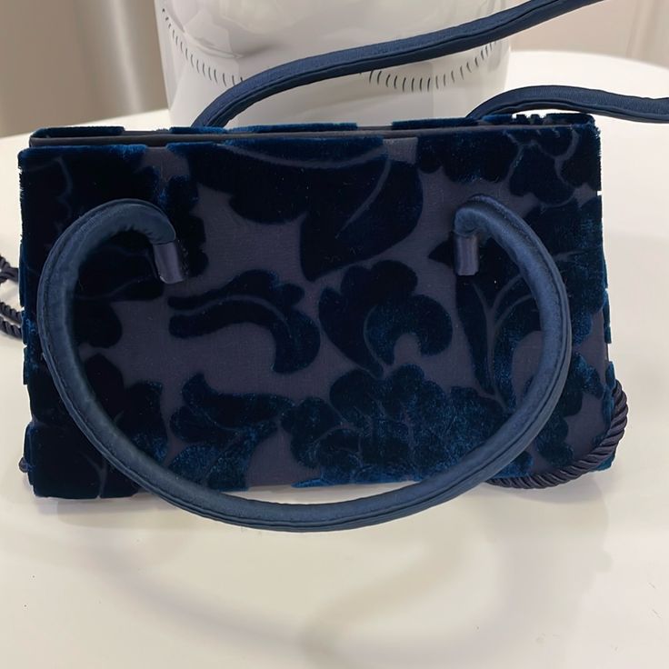 Vintage Early 2000’s Bloomingdale’s Own Tone On Tone Navy Blue Velvet Floral Pattern On Navy Blue Silk Like Fabric. Can Be Used As Hand Held Or Shoulder. Fabric Double Handles Single Navy Rope Shoulder Strap. Footed Bottom Protects This Delicate And Feminine Bag. Snap Top Closure. New W/O Tags. Never Used. Vintage! Designer Blue Tote Box Bag, Designer Blue Bag With Double Handle, Designer Blue Handheld Satchel, Designer Blue Box Bag For Shopping, Designer Blue Box Shoulder Bag, Designer Blue Box Bag With Removable Pouch, Designer Blue Bag With Top Carry Handle, Designer Blue Box Bag For Everyday Use, Designer Blue Satchel For Formal Occasions