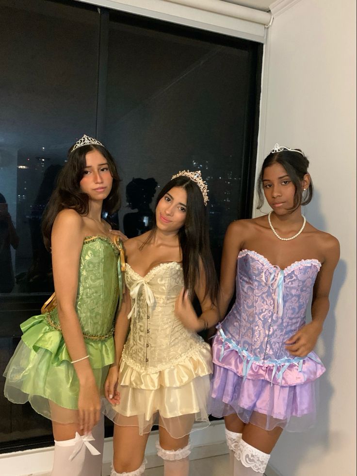 three young women dressed in costumes standing next to each other