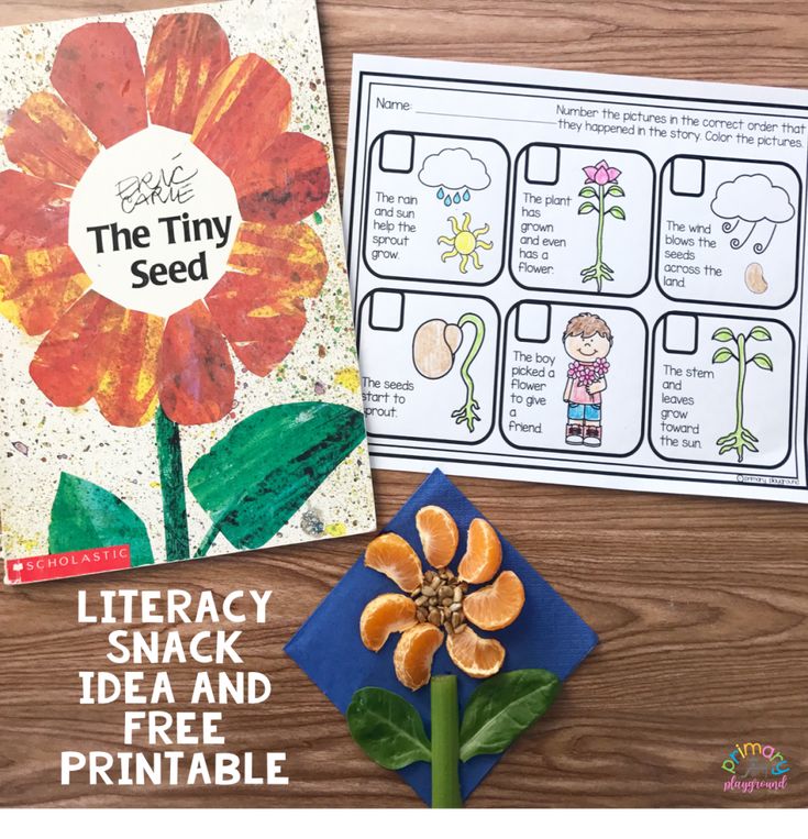 an orange flower next to a book about the tiny seed on a wooden table with other books