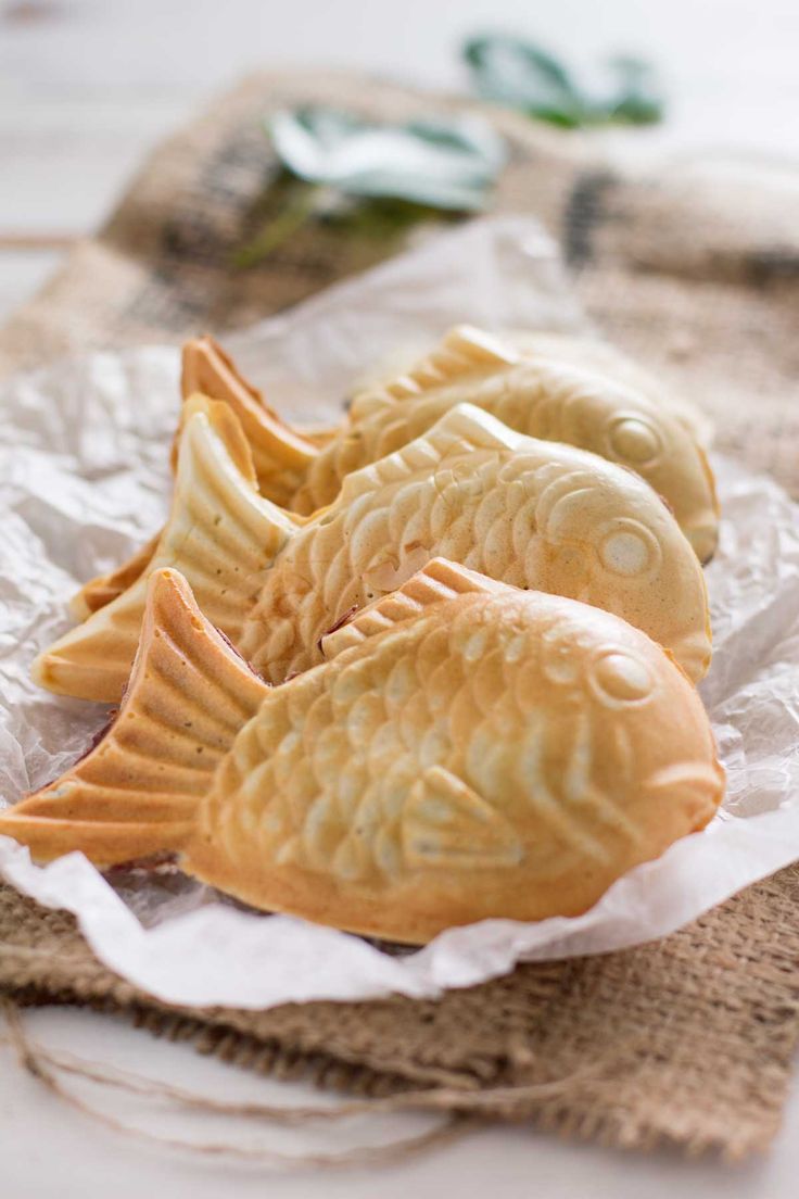 three cookies shaped like fish sitting on wax paper