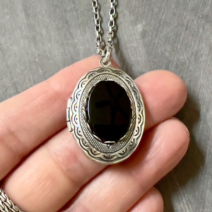 Antique Silver Onyx Locket Necklace....  This locket necklace is beautiful!  The locket is made of brass and is antique silver plated.  To the center of the locket, I added a flat top oval black onyx cabochon that sits in an antiqued silver brass setting. The high quality chain has soldered links and is non tarnish.  The chain closes with a lobster claw clasp.        Locket - 1.30 inches high x .91 inches wide OR (33mm x 23mm) Interior photo area - 28mm high x 20mm wide approx. This sweet vintage style locket would be perfect to add photos of relatives, friends or pets. Your locket necklace will come to you gift wrapped!   More beautiful lockets!  https://www.etsy.com/shop/dayslonggone/?etsrc=sdt&section_id=6107145 Nature and vintage inspired necklaces!  https://www.etsy.com/shop/dayslongg Antique Silver Pendant Necklaces For Keepsake, Nickel Free Antique Silver Necklace, Antique Silver Pendant Necklace For Keepsake, Victorian Style Necklace With Oxidized Finish For Gifts, Victorian Style Necklace With Oxidized Finish, Vintage Black Necklace With Oxidized Finish, Black Amulet Locket Jewelry, Metal Oval Locket Necklace, Black Enamel Oval Necklace For Gift