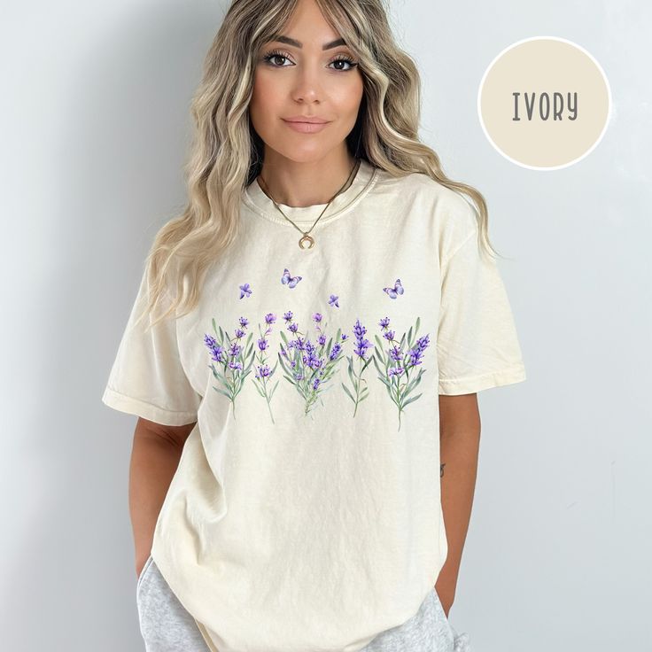 Lavender Wildflowers Comfort Colors® T-Shirt, Summer Wildflowers Tee Shirt, Lavender Shirt, Summer Wildflowers Shirt Gift, Lavender Gift Tee. Orders are processed within 24 hours and shipped out within 2 to 5 business days. What you receive: Comfort Colors® Adult Unisex Crewneck T-shirt Color Choices: Ivory White Pepper Orchid Sizes: Unisex adult sizing use size chart as a guide. These shirts are fitted and run true to size. If you prefer a loose fit go one size larger. If you want an oversized Lavender Floral Print Cotton Top, Lavender Cotton Tops With Floral Print, Purple Floral Embroidered Crew Neck Top, Purple Crew Neck Top With Floral Embroidery, Lavender Relaxed Fit T-shirt For Spring, Lavender Graphic Print Crew Neck Top, Summer Lavender Tops With Graphic Print, Lavender Crew Neck Top With Graphic Print, Lavender Graphic Print Tops For Summer