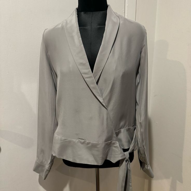 Elevate Your Wardrobe With This Stunning J Brand Blouse. Made From 100% Silk, Size Medium, And In A Gorgeous Light Gray Color. The Long Sleeves And V-Neckline Are Complemented By A Front Tie Closure, Adding A Touch Of Elegance To Any Outfit. Perfect For Work Or Any Occasion! Retailed For $248 + Tax! Chic Silver V-neck Top, Elegant Gray Long Sleeve Tops, Elegant Long Sleeve Gray Tops, Gray Formal Tops For Fall, Gray Tops For Spring Evening, Gray Tops For Evening In Spring, Fall Season Silver V-neck Top, Gray V-neck Blouse For Workwear, Gray V-neck Blouse For Work