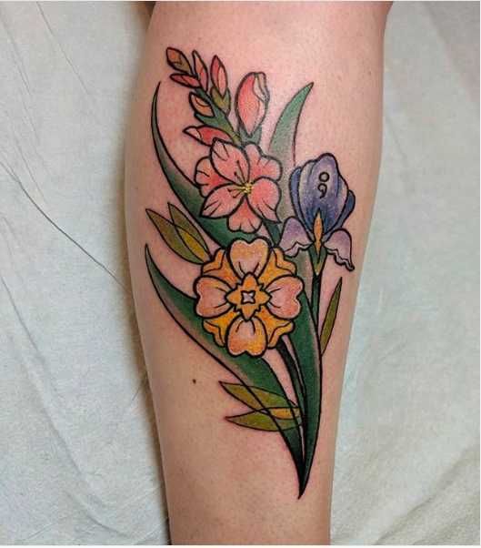 a woman's leg with flowers and leaves on it