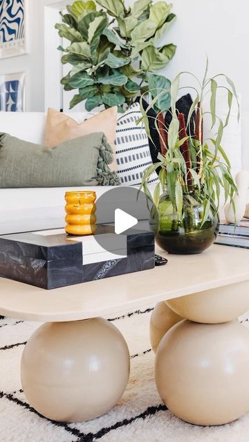 a living room filled with furniture and plants on top of a table in front of a couch