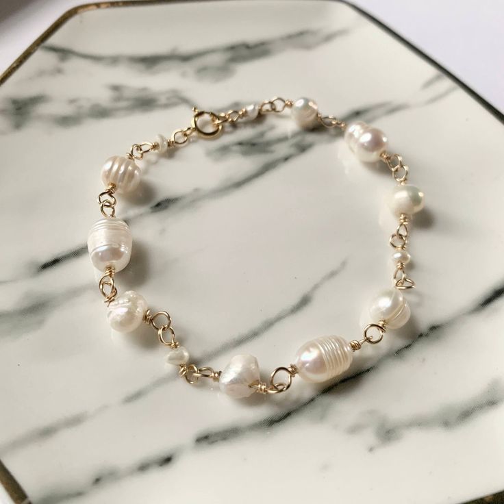 This real freshwater Pearl bracelet with genuine gemstone beads will be a dainty but unique addition to any wedding ensemble - or a great gift for those with June birthdays.  This bracelet is made with seed/potato pearls and one focal freshwater Pearl in the center of the bracelet. This piece is perfect for stacking and provides the timeless style of pearls with a delicate twist.  This bracelet is available in 14k gold filled wire and claspx but sterling silver is also available - high-quality y June Zodiac, Gemini Birthday, Jewelry Bridesmaid, Etsy Bridesmaid Gifts, Freshwater Pearl Bracelet, Wedding Jewelry Bracelets, Gemstone Beaded Bracelets, June Birthstone, June Birth Stone