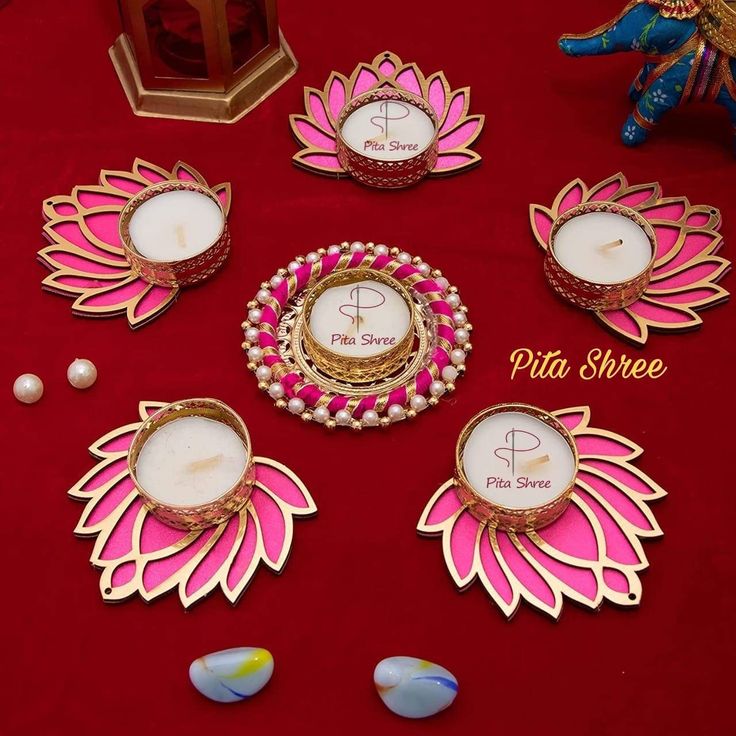 some pink and white plates sitting on a red table cloth with other items around them