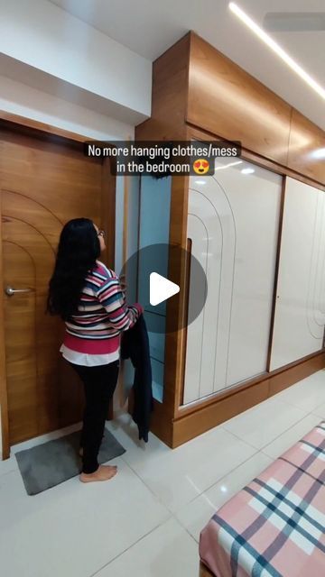 a woman standing in front of a closet next to a bed