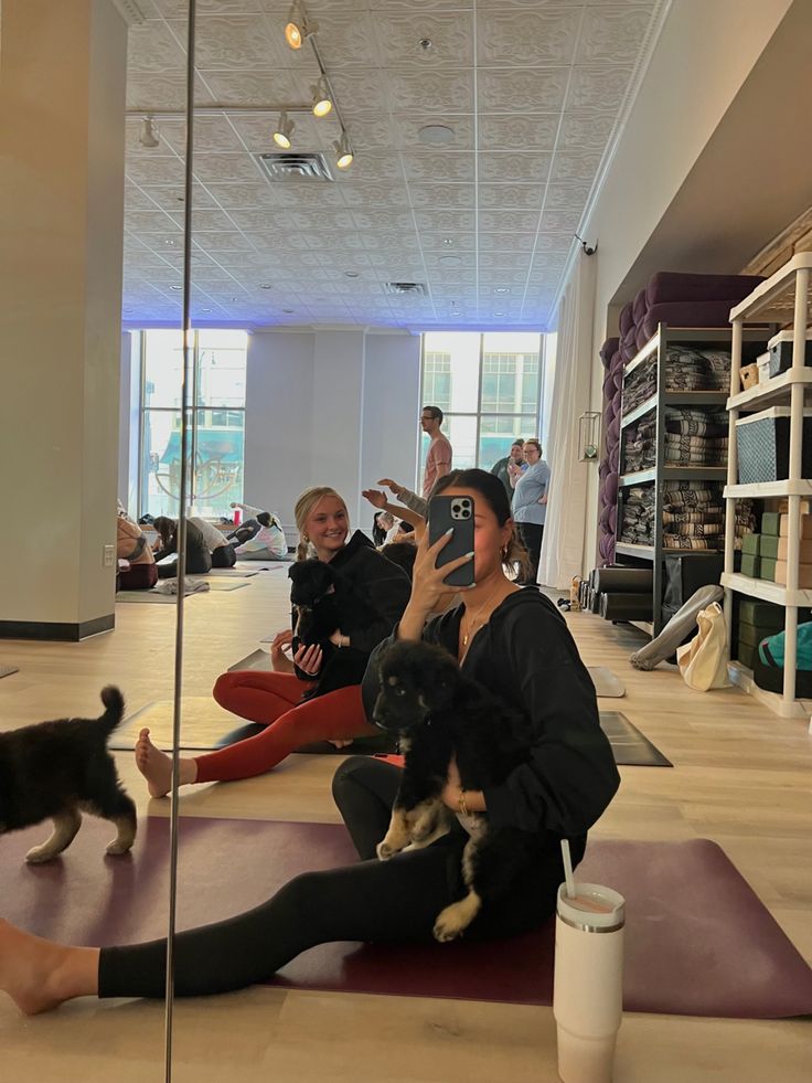 a woman taking a selfie with her dog in the middle of a yoga class