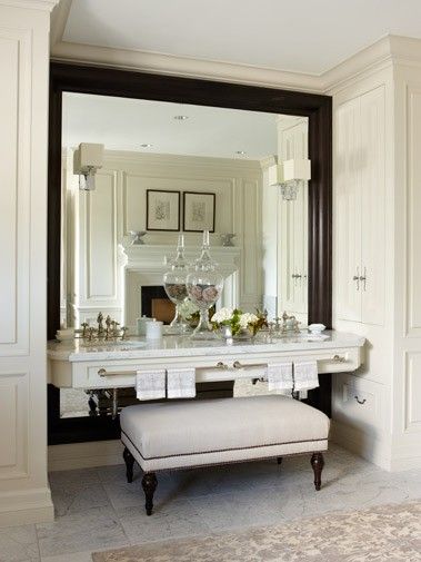 a white vanity with a bench in front of it